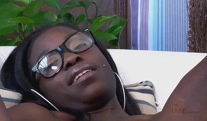 Ebony with glasses shows off her figure while pleasuring herself