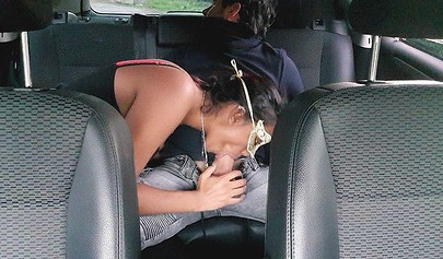 Beauty gives a blowjob to her man in the back seat
