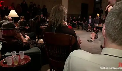 Hot ebony girl performs BDSM sexual acts in front of a large male audience