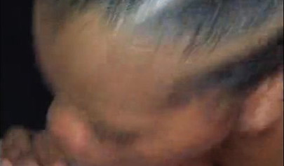 Busty ebony babe sucks cock while lying down on her stomach like a real pro would