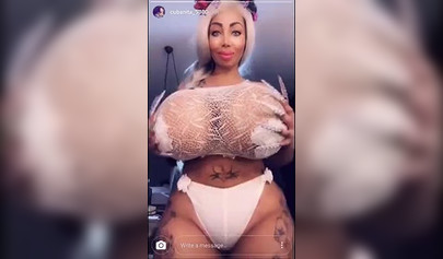 Black chick with implants shows her massive titties and loves the feeling of it