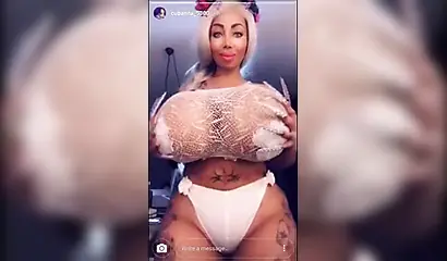 Black chick with implants shows her massive titties and loves the feeling of it