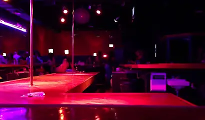 Ebony chick with massive tits and a huge belly dances in an empty strip club