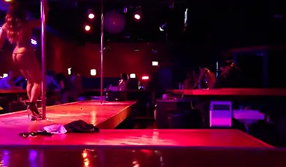Ebony chick with massive tits and a huge belly dances in an empty strip club