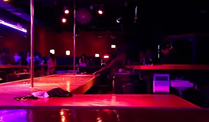 Ebony chick with massive tits and a huge belly dances in an empty strip club