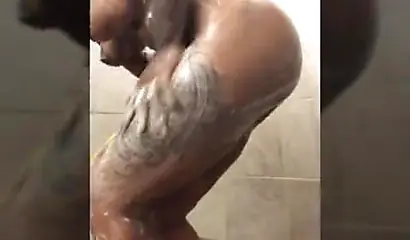 Horny mature ebony with short blonde hair masturbates vigorously while in a shower