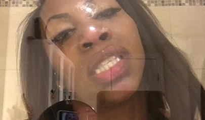 Black amateur stripper kisses the glass and is horny while under the shower