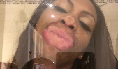 Black amateur stripper kisses the glass and is horny while under the shower