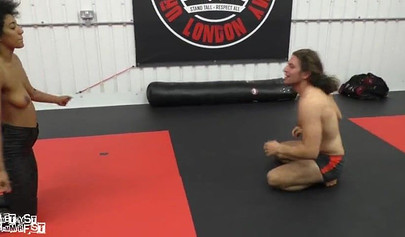 Athletic ebony babe wrestles topless with a white guy and subdues him erotically