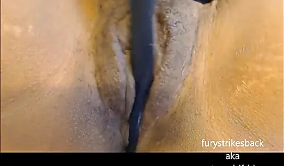 Ebony chick with a cunt that is not shaved fucks herself in it until she cums