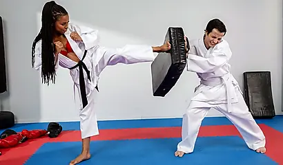 Adorable black beauty is giving footjob at a karate lesson